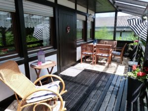 Überdachte Veranda mit Sitzmöbeln